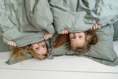 Portrait of cute girl lying on bed at home