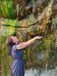 Side view of woman standing on rock