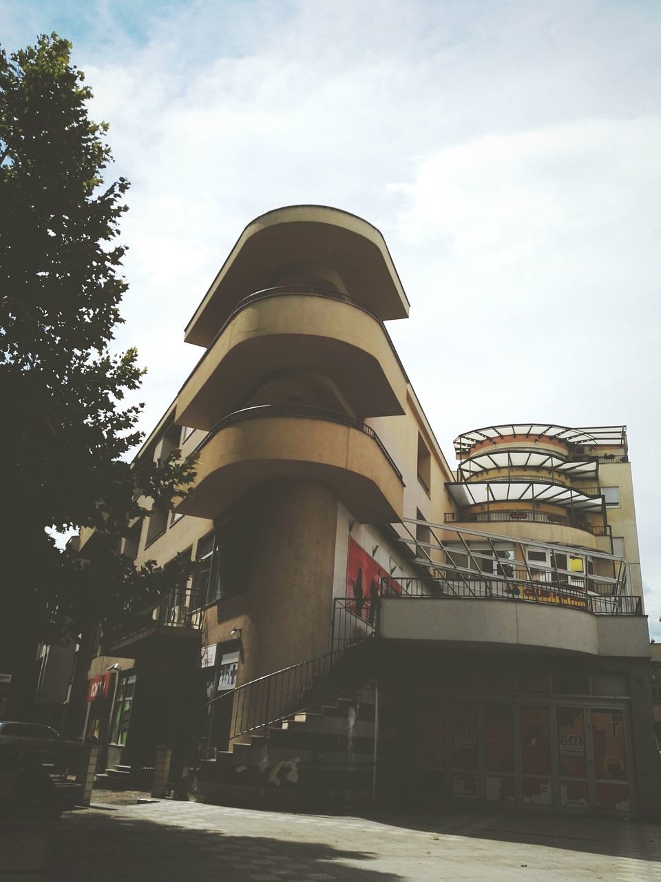 architecture, built structure, building exterior, low angle view, sky, tower, tall - high, cloud, outdoors, entrance, day, tall, office building, modern, architectural feature, facade, spire, no people