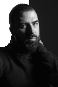 Portrait of young man against black background