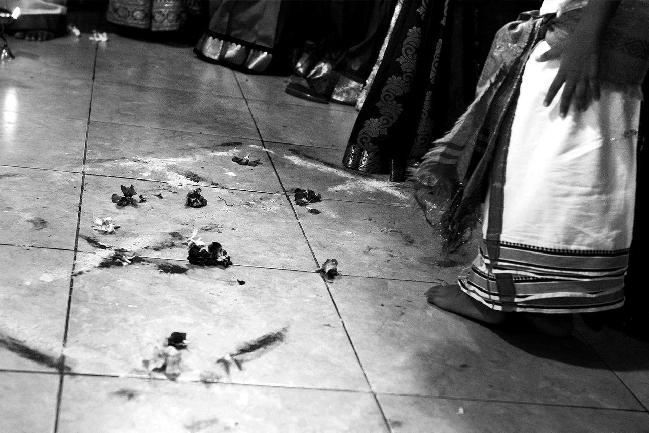 LOW SECTION OF MAN STANDING IN TILED FLOOR