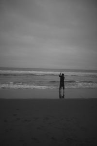 Full length of man walking on beach against sky