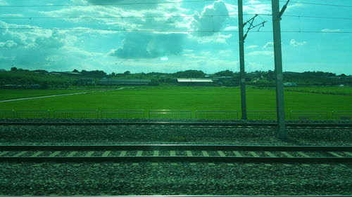 Railroad tracks on field against sky