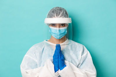 Portrait of woman against blue background