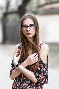 Young brown-haired millennial with glasses and light dress