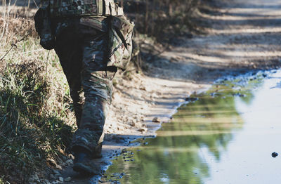 Low section of man walking by puddle