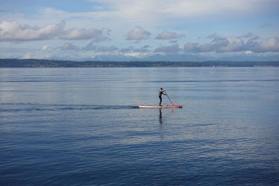 Man surfing in sea against sky