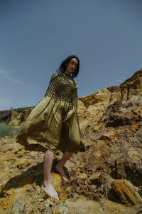 Portrait of young woman standing on rock