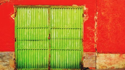 Closed green door of red house