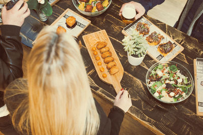 High angle view of friends having food at table in bar