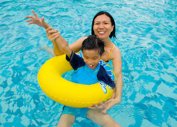 High angle view of woman with son in swimming pool