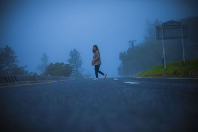 Full length of woman walking on road in city