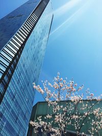 Low angle view of modern buildings against blue sky