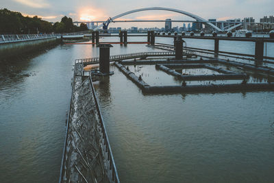 Bridge over river against sky during sunset