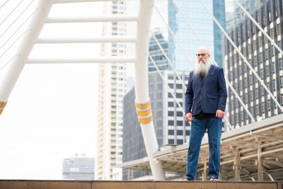 Portrait of man standing against built structure