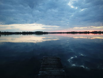 Scenic view of calm lake against cloudy sky