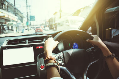 Midsection of man using mobile phone in car