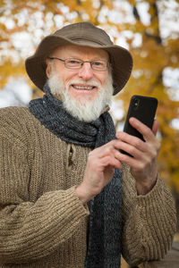 Portrait of man using mobile phone while sitting by table