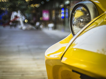 Close-up of yellow car on street