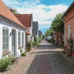 Footpath amidst buildings against sky
