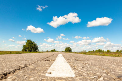 Surface level of empty road against blue sky