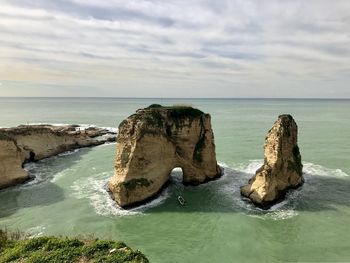 Scenic view of rocks in sea against sky