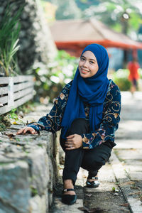 Portrait of smiling young woman against blurred background