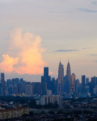 Modern buildings in city against sky during sunset