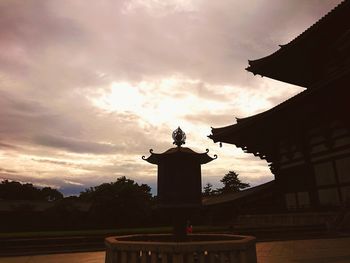 Low angle view of silhouette statue against sky during sunset