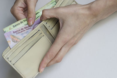 Close-up of woman holding hands over white background