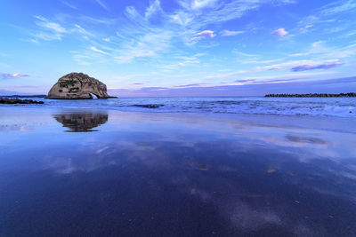 View of calm beach against blue sky