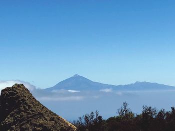 Scenic view of mountains against clear blue sky