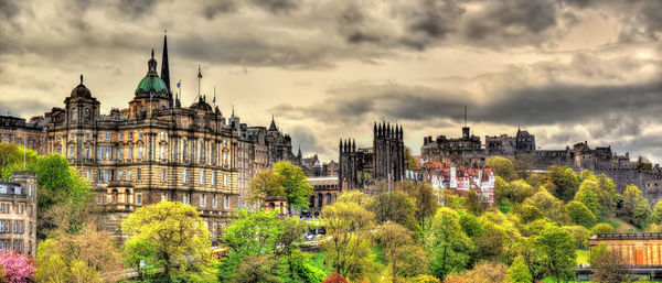 Panoramic view of buildings and trees against sky in city