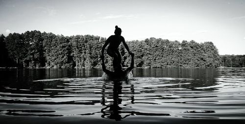 Silhouette man overlooking calm lake