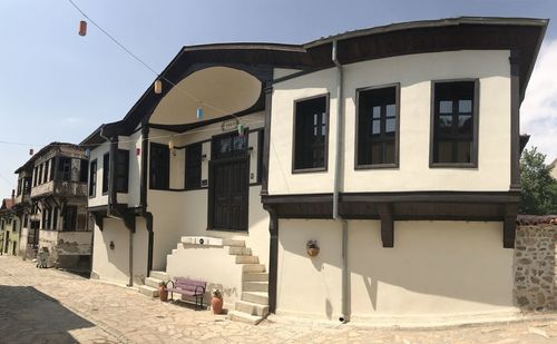 Street by buildings against sky in city