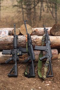 Close-up of rifle on logs