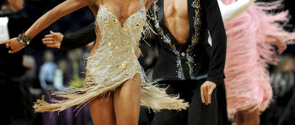 Midsection of man and woman dancing at event