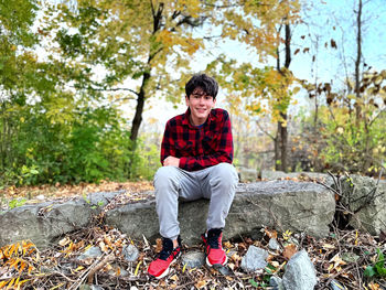 Young man sitting on rock