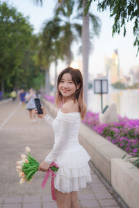 Portrait of young woman standing in city