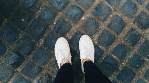 Low section of person standing on tiled floor