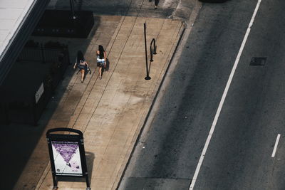 High angle view of friends walking on footpath by street