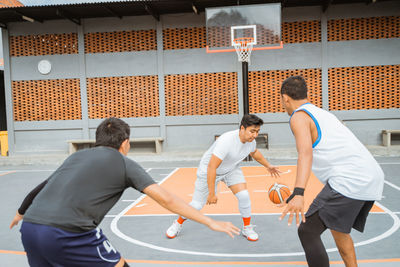 Rear view of people playing basketball