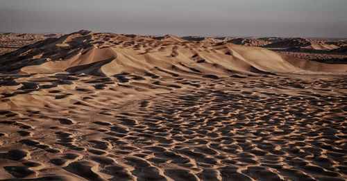 Sand dunes in desert against sky