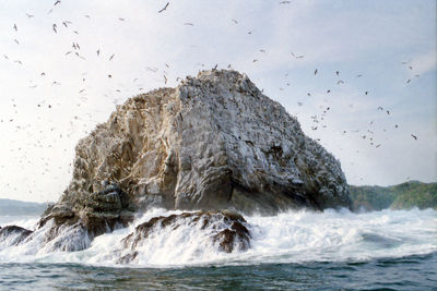 Scenic view of rocks in sea against sky