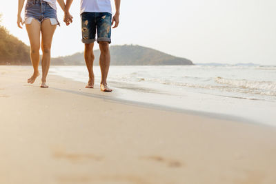 Rear view of people walking on beach