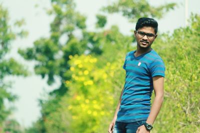 Portrait of young man standing against plants