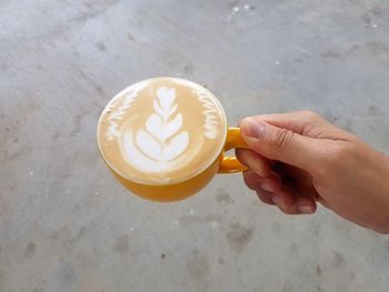 Close-up of hand holding coffee cup