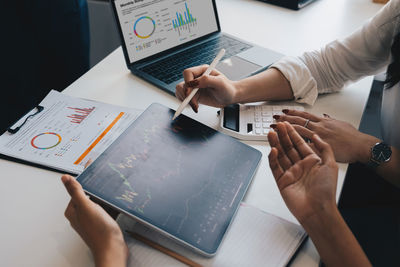 Cropped hands of business colleagues working on table