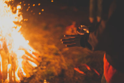 Person holding burning fire at night