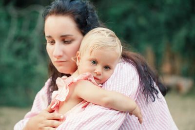 Close-up of mother and daughter embracing outdoors